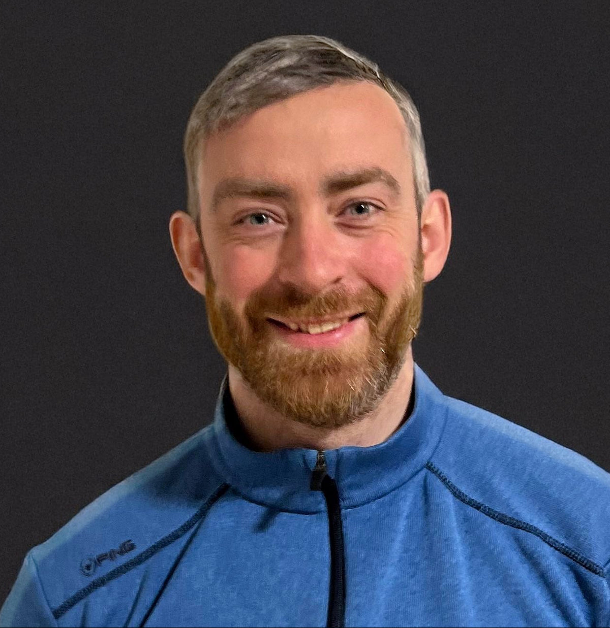 Man wearing a blue jacket against a black background